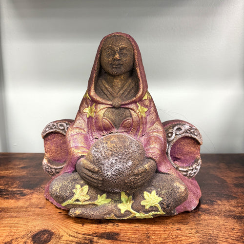 Decorative statue of a seated figure with a hood on a wooden surface #87148