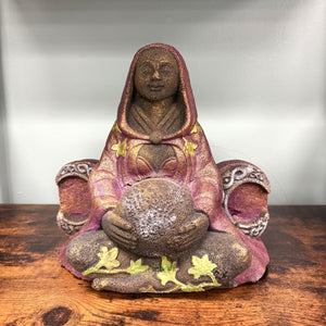 Decorative statue of a seated figure with a hood on a wooden surface #87148